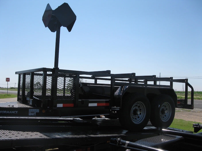 Black utility trailer with a cage on a clear day