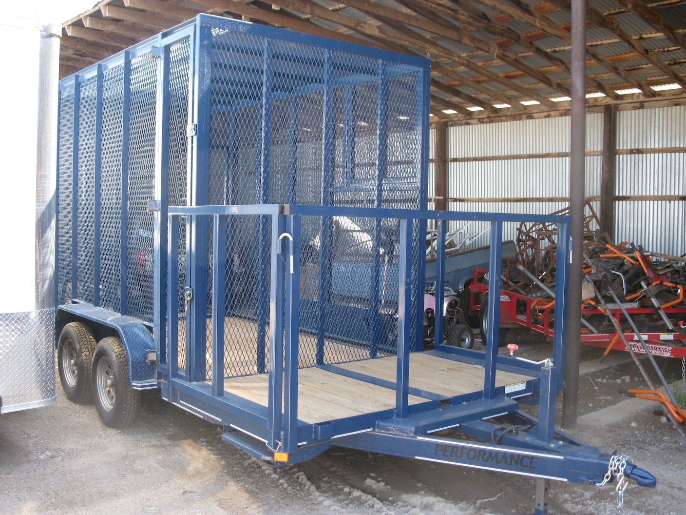 Blue metal trailer with a cage inside a warehouse.